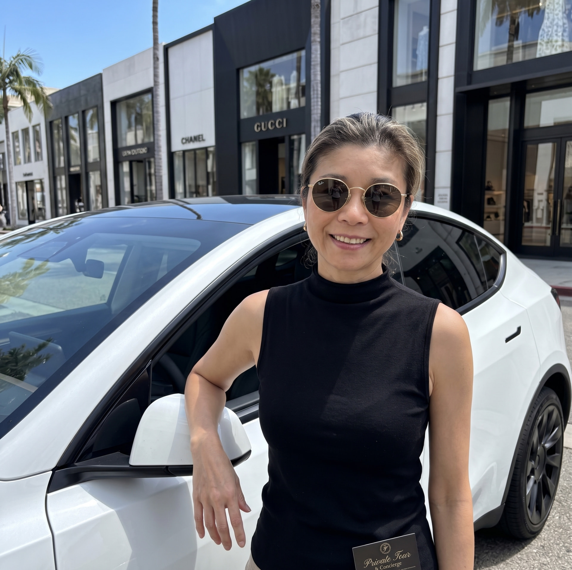 The Cocoridge chauffeur standing beside a white luxury vehicle on a sunny city street